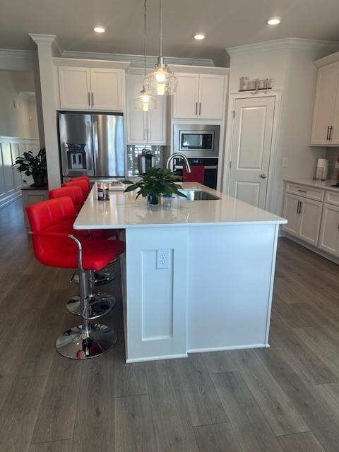 kitchen featuring stainless steel appliances, white cabinets, crown molding, and a sink