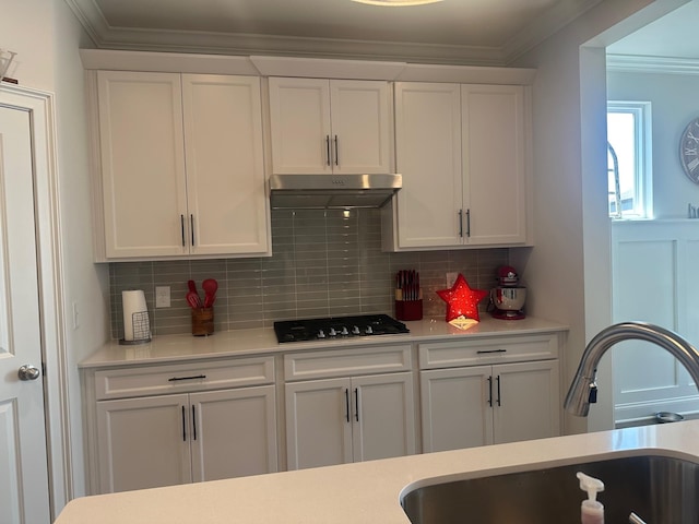 kitchen featuring ornamental molding, black gas stovetop, a sink, and under cabinet range hood