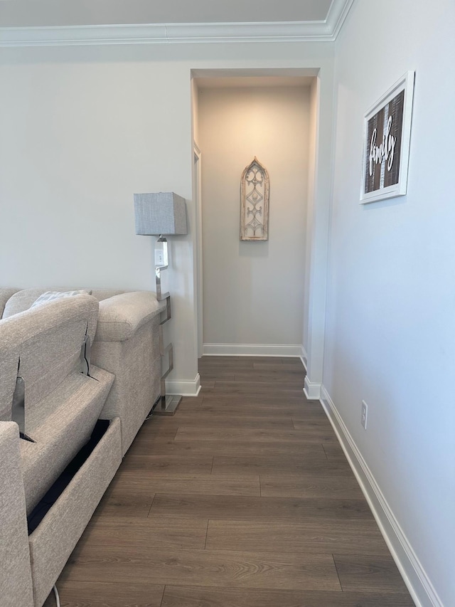 corridor with ornamental molding, dark wood finished floors, and baseboards