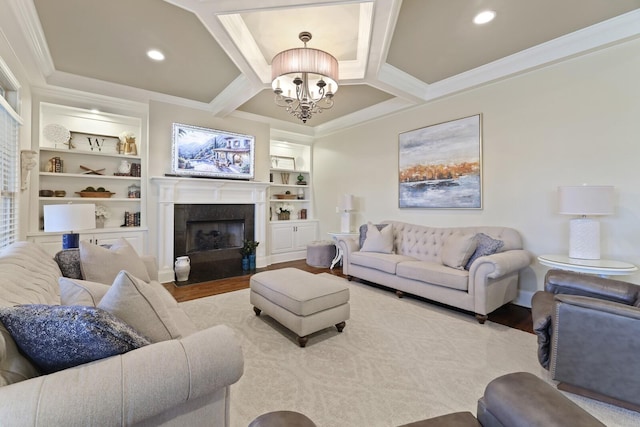 living room with built in shelves, ornamental molding, light wood-type flooring, and a notable chandelier