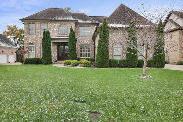 view of front of home with a front yard, french doors, and a garage