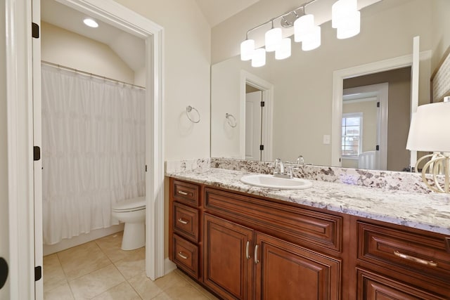 bathroom featuring tile patterned floors, vanity, vaulted ceiling, and toilet