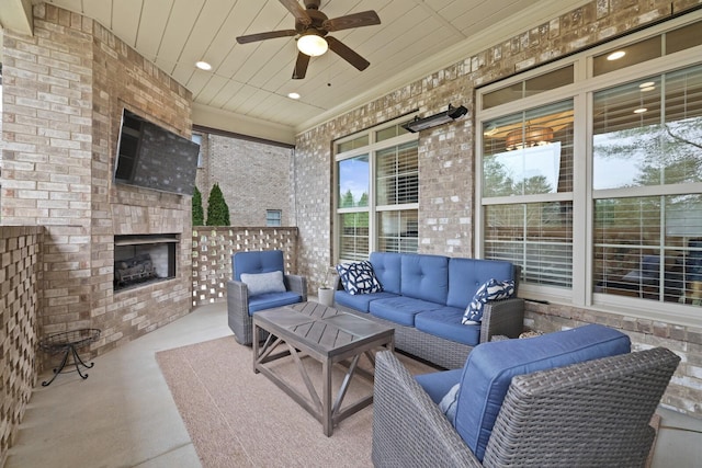 view of patio with an outdoor living space with a fireplace and ceiling fan