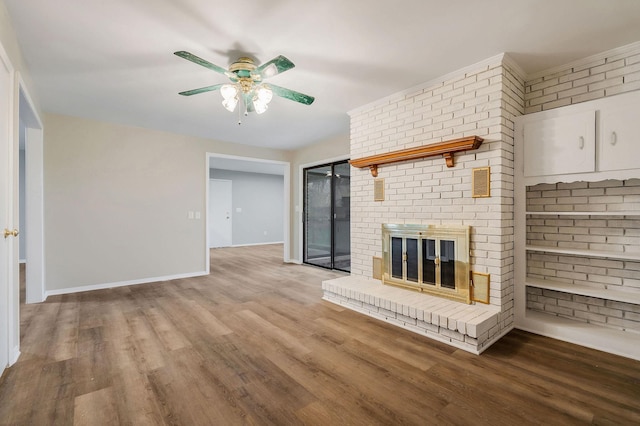 unfurnished living room featuring a fireplace, hardwood / wood-style floors, and brick wall