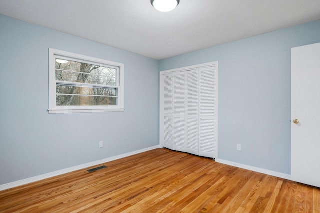 unfurnished bedroom featuring a closet and light wood-type flooring