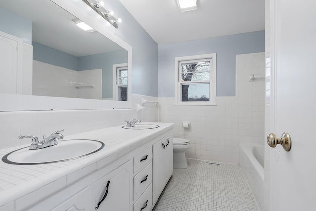 full bathroom featuring vanity, tiled shower / bath combo, tile walls, tile patterned flooring, and toilet