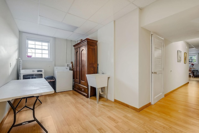 washroom with washer and clothes dryer and light hardwood / wood-style flooring