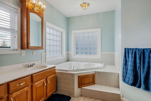 bathroom featuring vanity, a relaxing tiled tub, tile patterned floors, and an inviting chandelier