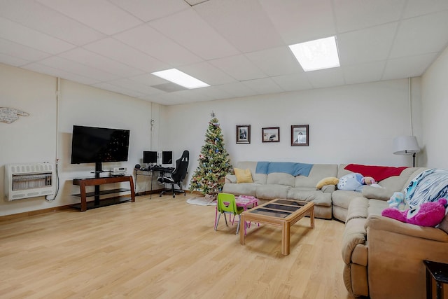 living room with heating unit, a paneled ceiling, and hardwood / wood-style floors