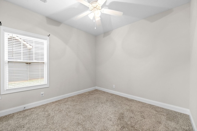 spare room featuring ceiling fan and carpet