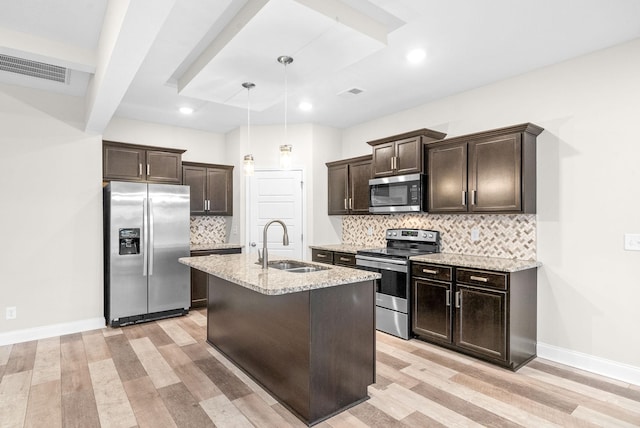 kitchen featuring sink, hanging light fixtures, stainless steel appliances, dark brown cabinetry, and light wood-type flooring