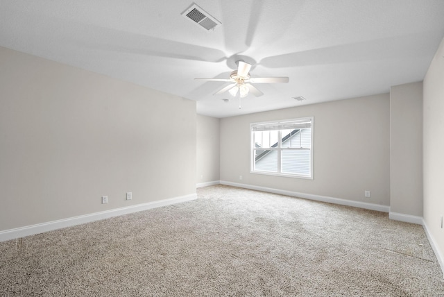 unfurnished room with ceiling fan and carpet