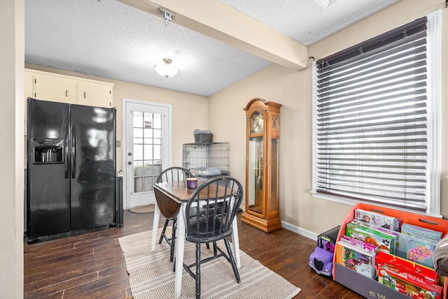 dining space featuring beamed ceiling, dark hardwood / wood-style floors, and a wealth of natural light