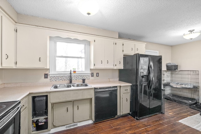 kitchen with black appliances, dark hardwood / wood-style flooring, sink, and a textured ceiling