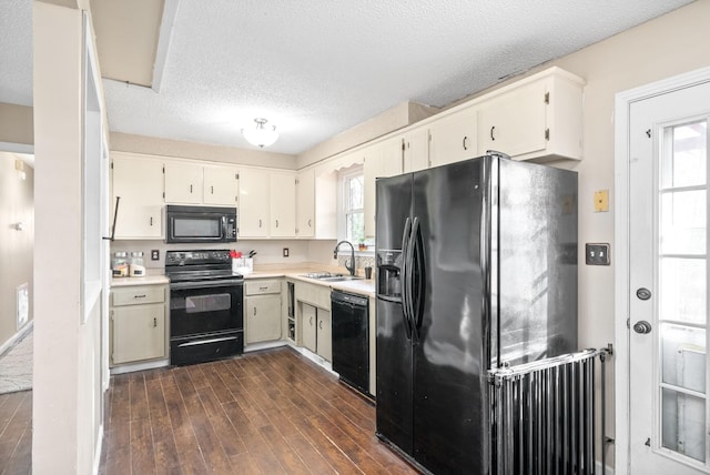 kitchen with dark wood-type flooring, black appliances, plenty of natural light, and sink