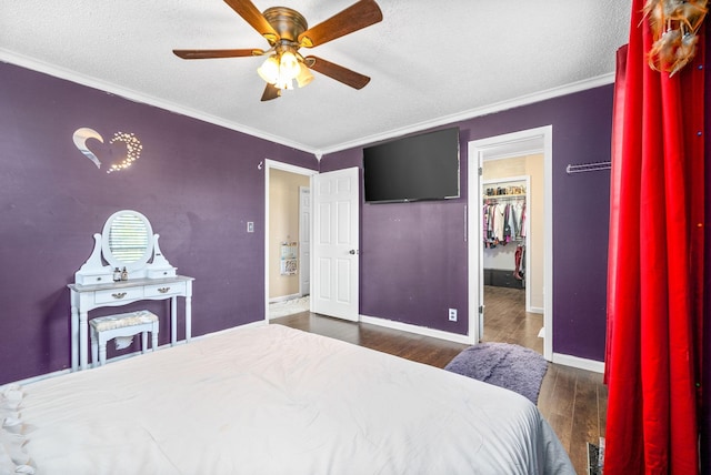 bedroom with a textured ceiling, ceiling fan, dark hardwood / wood-style floors, and ornamental molding