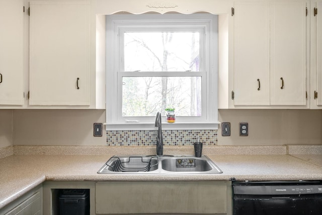 kitchen featuring a wealth of natural light, dishwasher, white cabinets, and sink