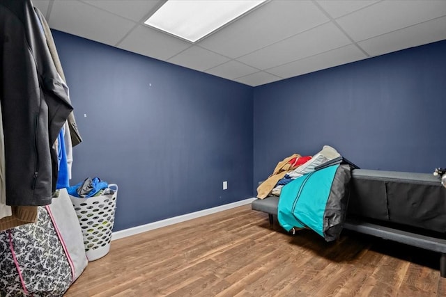 bedroom with a drop ceiling and wood-type flooring