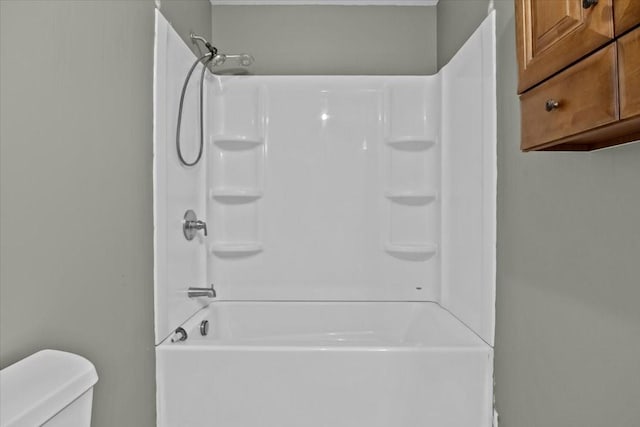 bathroom with washtub / shower combination and toilet