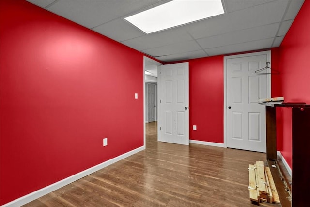 empty room featuring hardwood / wood-style flooring and a drop ceiling