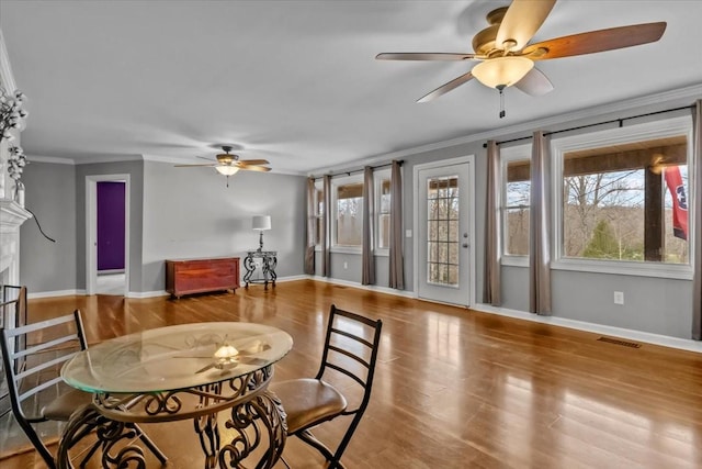 dining space with light hardwood / wood-style flooring, ceiling fan, and crown molding