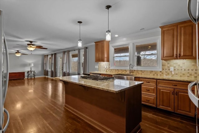 kitchen featuring sink, hanging light fixtures, dark hardwood / wood-style floors, ceiling fan, and light stone countertops