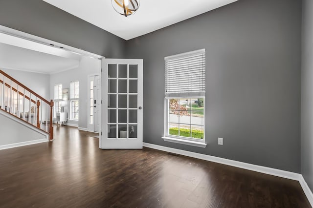 spare room featuring french doors and dark wood-type flooring