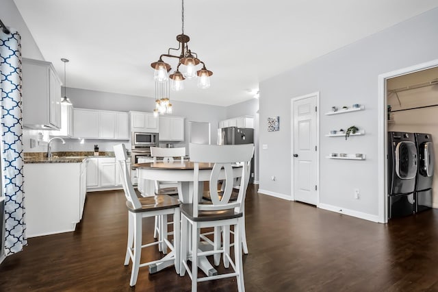 kitchen with pendant lighting, stainless steel microwave, separate washer and dryer, dark hardwood / wood-style flooring, and white cabinetry