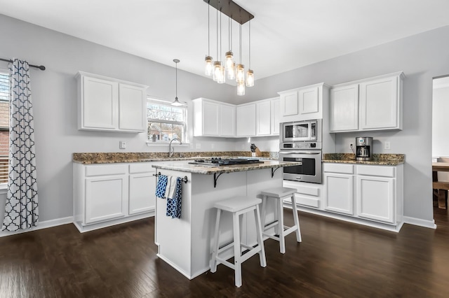 kitchen with dark hardwood / wood-style floors, a center island, white cabinetry, and stainless steel appliances