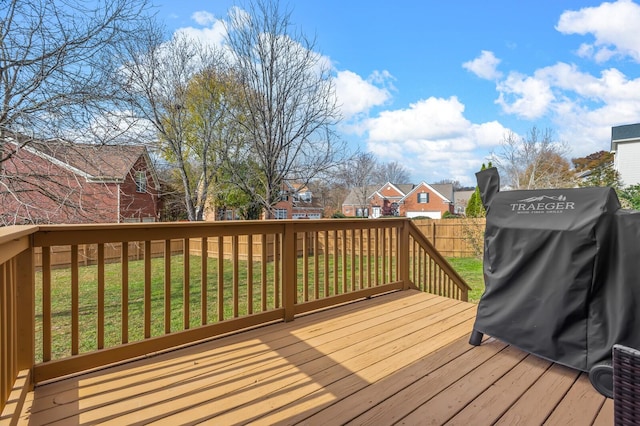 wooden terrace with a lawn and a grill