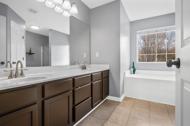 bathroom featuring tile patterned flooring, a bathtub, and vanity