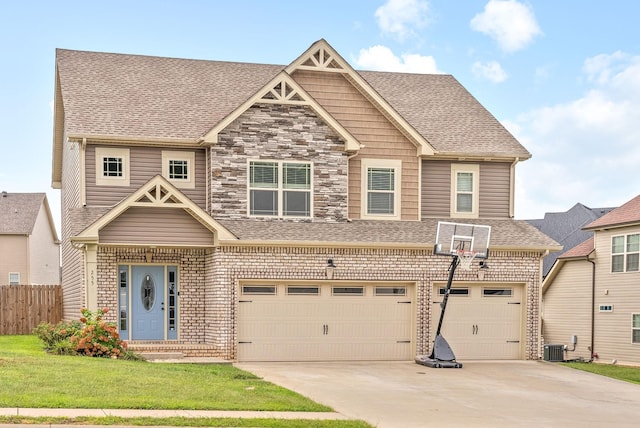 craftsman house with a garage, a front lawn, and central air condition unit