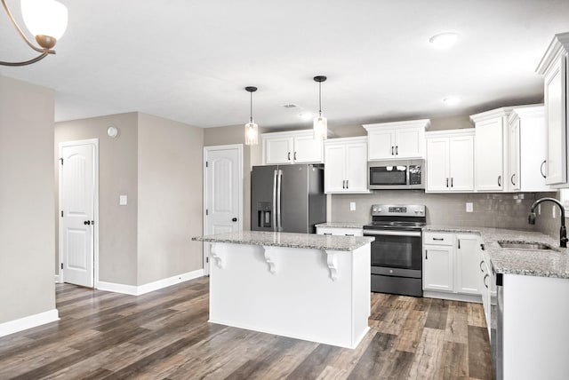 kitchen featuring dark wood-type flooring, sink, a kitchen island, white cabinetry, and stainless steel appliances