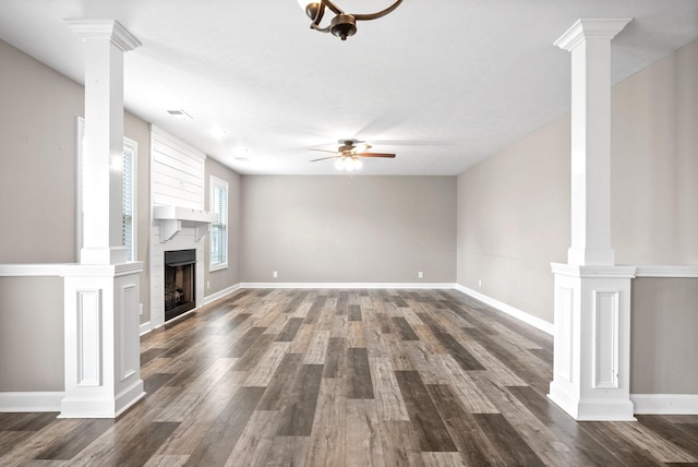 unfurnished living room with a textured ceiling, a large fireplace, ceiling fan, and dark wood-type flooring