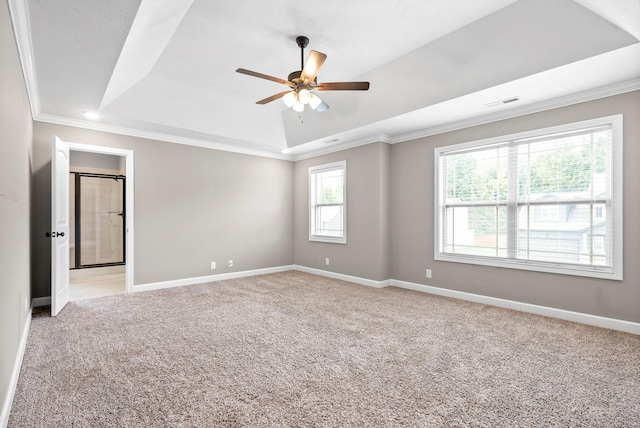 spare room with light carpet, a tray ceiling, ceiling fan, and ornamental molding