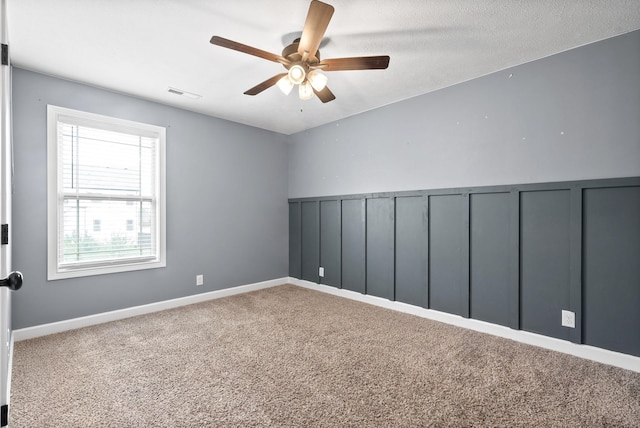 carpeted empty room with a textured ceiling and ceiling fan