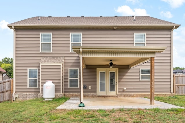 rear view of property featuring ceiling fan, a yard, and a patio