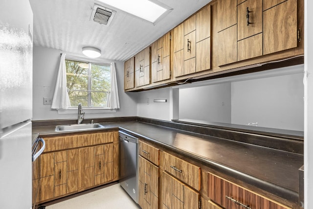 kitchen with white refrigerator, stainless steel dishwasher, and sink