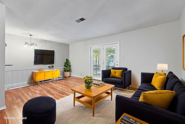 living room featuring a chandelier and light hardwood / wood-style floors