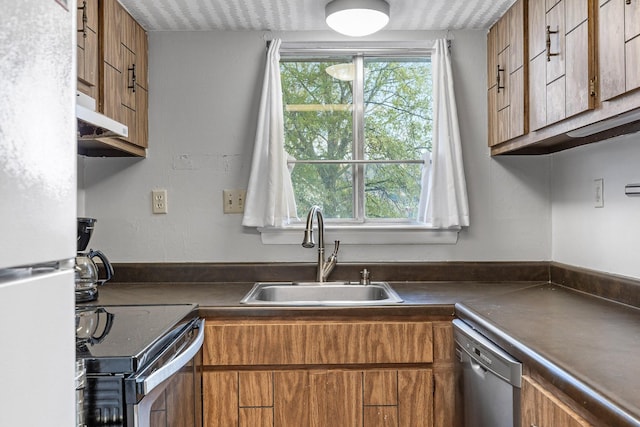 kitchen with a textured ceiling, sink, and appliances with stainless steel finishes