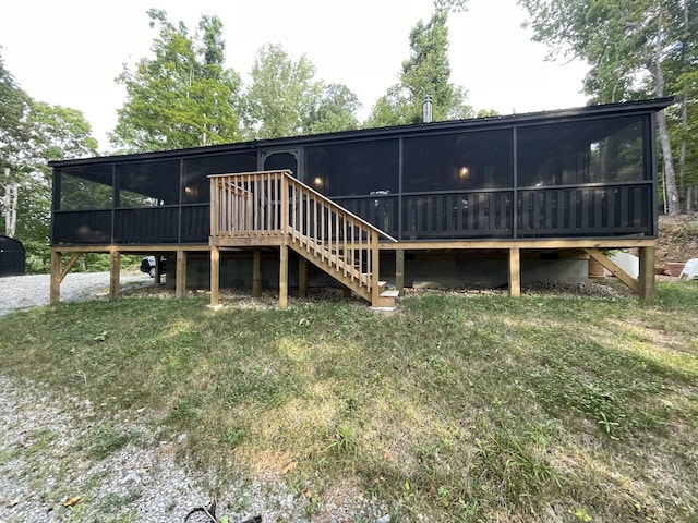 rear view of house featuring a sunroom and a yard