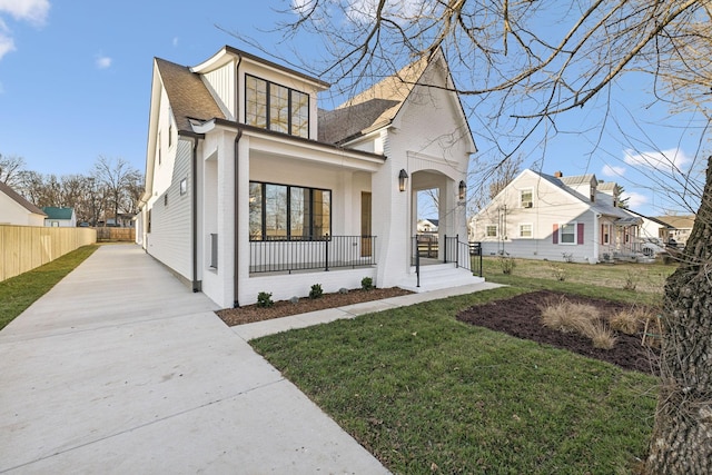 view of front of home with covered porch and a front lawn