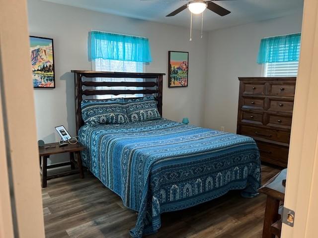 bedroom with ceiling fan and dark wood-type flooring