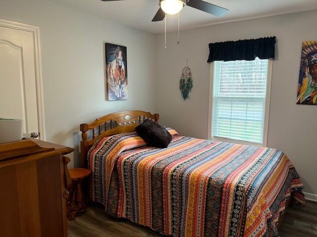 bedroom with dark hardwood / wood-style flooring and ceiling fan