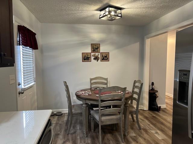 dining space with wood-type flooring and a textured ceiling