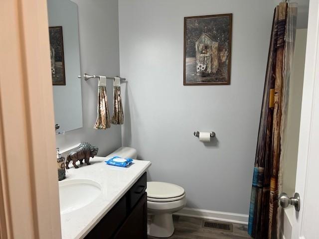 bathroom with hardwood / wood-style floors, vanity, and toilet