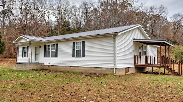 back of property featuring a lawn and covered porch