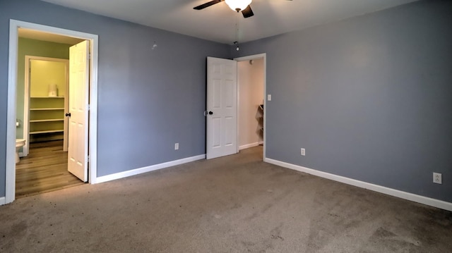 unfurnished bedroom with a spacious closet, carpet floors, and ceiling fan