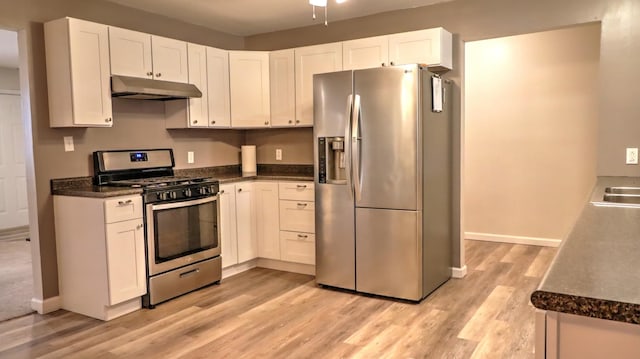 kitchen with white cabinets, appliances with stainless steel finishes, light hardwood / wood-style floors, and sink