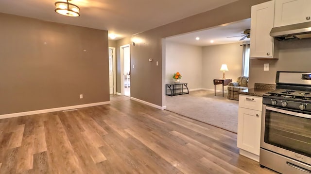 kitchen featuring ventilation hood, light hardwood / wood-style flooring, white cabinets, and stainless steel gas range